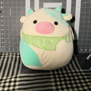 Squishmallow Belana the cow, with green bandana